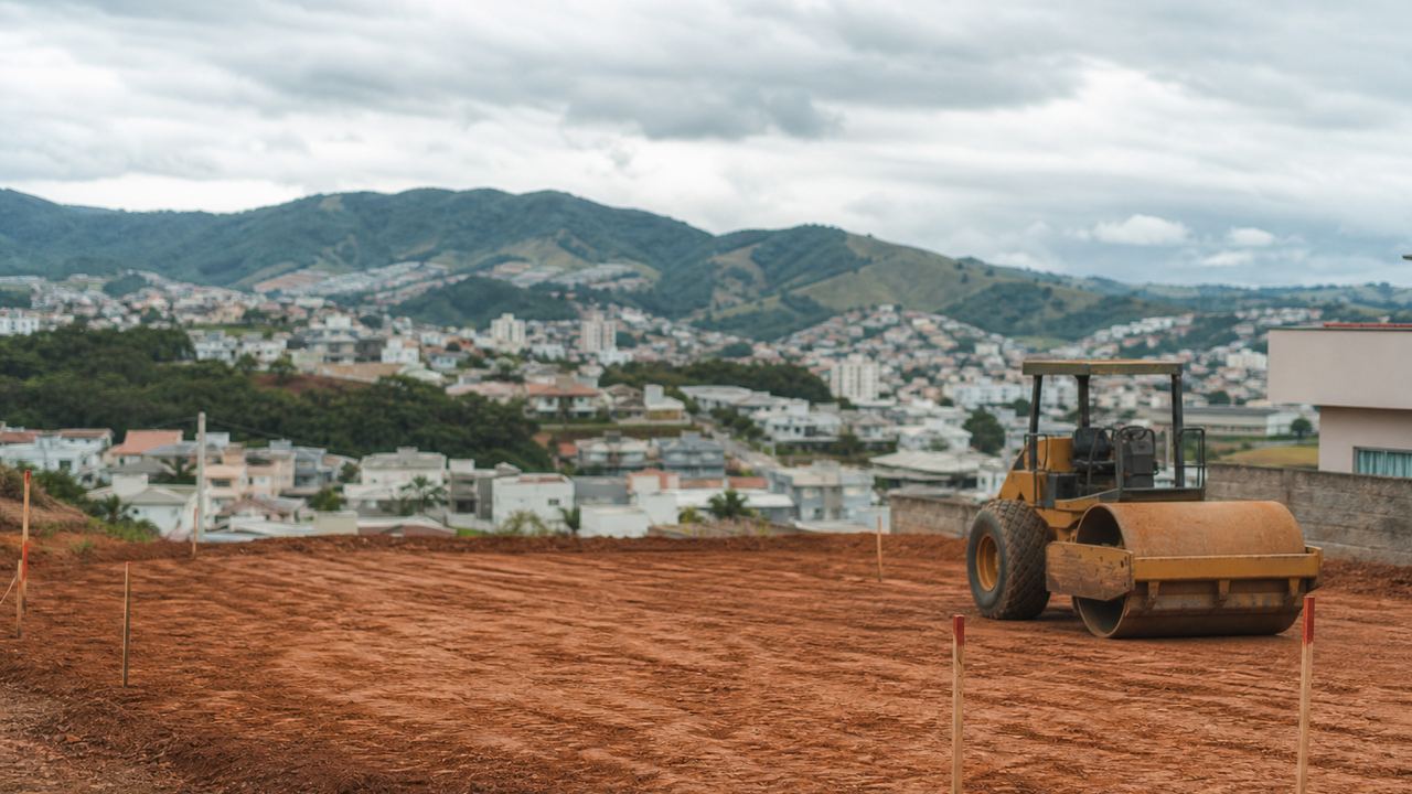 Terreno em preparo na borda de um bairro de Pouso Alegre, com solo vermelho recém-nivelado